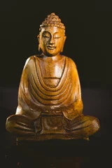 Poster Buddha statue over black background