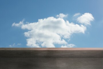 Large white cumulus cloud is drifting above concrete platform in flat design under bright blue sky