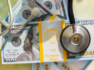 The image features a stack of hundred-dollar bills alongside a stethoscope, symbolizing the...