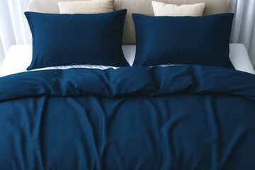 Cozy bed with two pillows and navy blue bedding