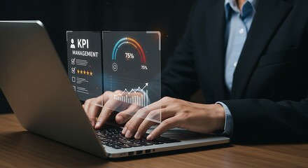 Man in suit using a laptop with a kpi management dashboard displayed on a holographic screen