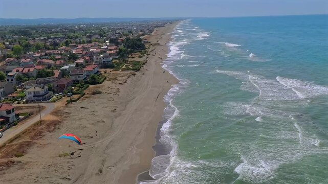 Aerial view of sandy beach and ocean with paramotor above, Karasu, Turkey.
