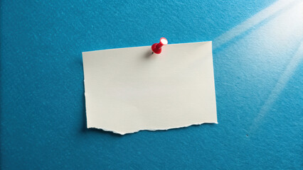 Clean minimalist overhead shot of white paper pinned to blue background, evoking simplicity