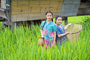 Group of pretty teenage travellers wearing custom-made Karen dresses in a natural green terraced...