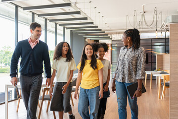 Diverse Group of Mentors and Students Walking and Talking in a Modern Space, Adult Professionals...
