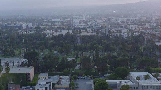 Telephoto dolly aerial shot of historic Hollywood Forever Cemetery at sunset in Los Angeles, California. 4K