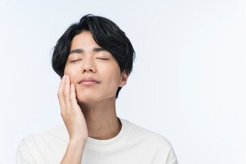 頬に手を当てている若い日本人男性