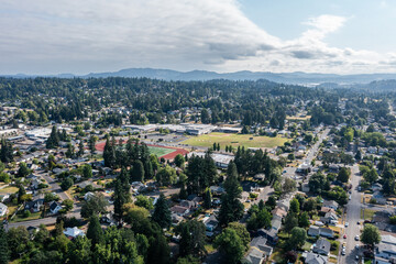 4K aerial drone picture of residential neighborhoods and straight grid streets in Gladstone, Oregon, showing homes, yards, and tree-lined blocks stretching into the distance