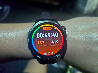 The smartwatch displays a workout report containing heart rate zone, duration, and calorie burn.