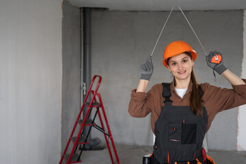 Female Builder Wearing Helmet Holding Measuring Tape Smiling at Camera on Construction Site