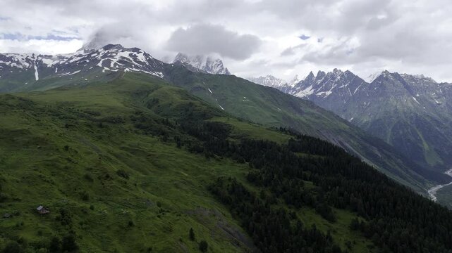 Aerial view of foggy Caucasus mountains near Koruldi Lake in Mestia, Georgia on a cloudy day