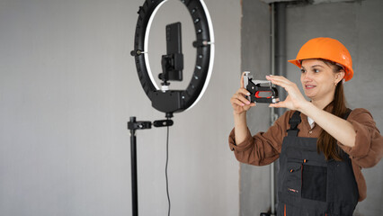 Female builder blogger live streaming tutorial showing construction stapler to social media...