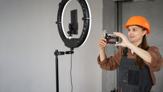 Female builder blogger live streaming tutorial showing construction stapler to social media followers