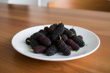 A simple yet elegant presentation of fresh mulberries, showcasing their natural beauty and vibrant color.