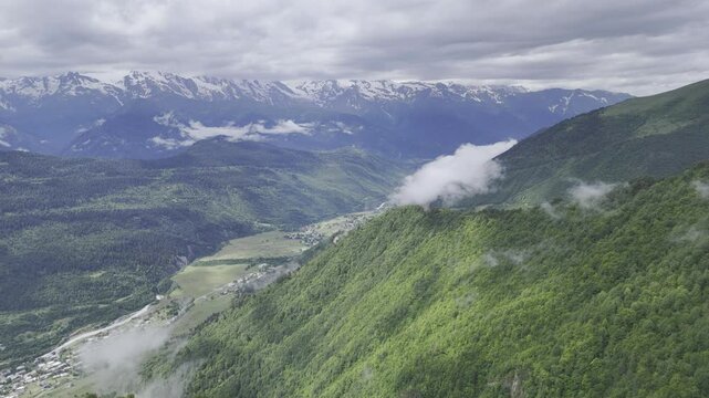 Aerial view of foggy Caucasus mountains near Koruldi Lake in Mestia, Georgia on a cloudy day
