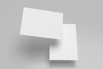 Two white A4 paper, magazine, or business card mockups floating diagonally with soft shadows isolated on grey background.
