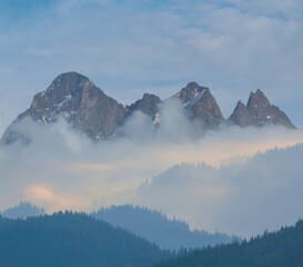 mountain chains in dense mist and clouds, summer mountain travel scene