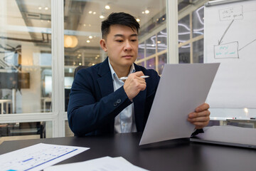 Young asian manager working on a new project and looking busy