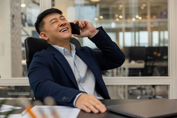 Young manager talking on the phone and feeling joyful and contented
