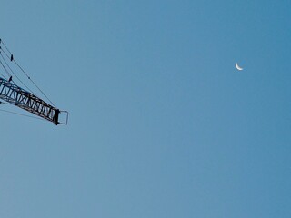 空に浮かぶクレーンと三日月