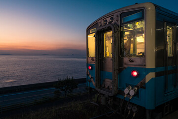 Seaside Train Passing by Sunset Coast in Japan