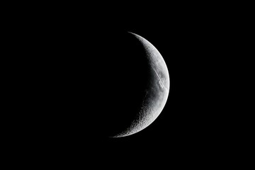 High-resolution photo of crescent moon in black night sky with detailed lunar surface texture
