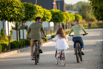 Family enjoying bike walk through neighborhood with greenery