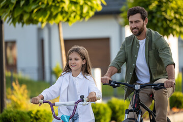 Obraz premium Family cycling adventure with father and daughter on home path