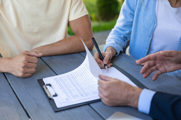Clients signing the contract with the real estate agent