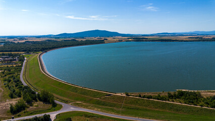Reservoir with a dam against the backdrop of the Krkanosz Mountains. Poland, Mietkow, Bozhigniew. Drone view.