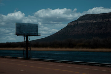 Billboard Overlooking Water and Mountain Landscape under Cloudy Blue Sky. Mock up promotion information for marketing announcements and details, blank white space