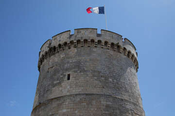 round medieval tower with french flag of ancient fortress of La Rochelle France