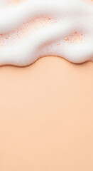 Fototapeta premium Soft white foam on pastel peach background creates soothing visual