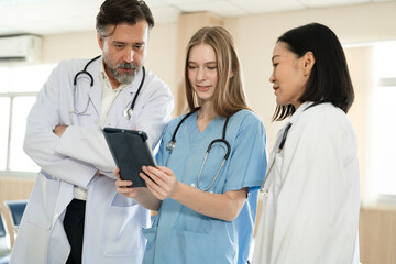 Caucasian woman doctor use tablet computer with team working at hospital	