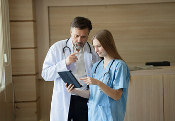 Caucasian woman doctor use tablet computer with team working at hospital	