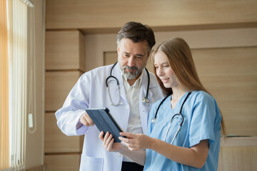 Caucasian woman doctor use tablet computer with team working at hospital	