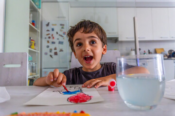 Excited child painting at home with watercolors