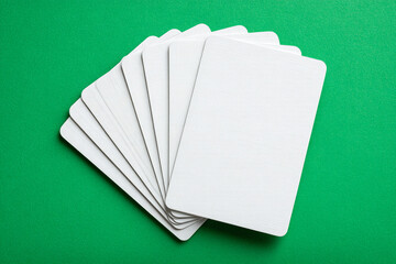 Blank White Playing Cards Fanned Out on Bright Green Background

