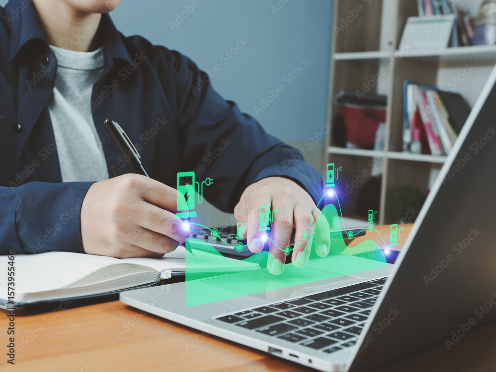 Poster person working on laptop with notebook and pen, digital energy icons and graph overlay, technology a