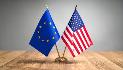 EU and US miniature flags side by side on wooden surface with gray background