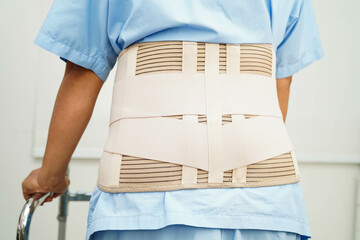 Asian woman wearing lumbar support pain back and use walker in hospital.
