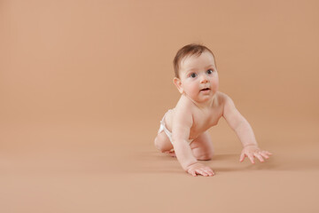 Cute little baby crawling on beige background. Space for text