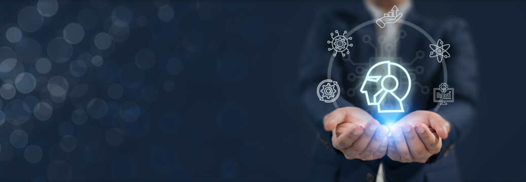 Human-AI collaboration concept. Businessman holds a glowing digital icon of a human-AI hybrid head, synergy between human intelligence and artificial intelligence in modern technology and innovation.