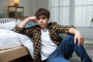 Teen problems. Upset teenage boy on floor at home