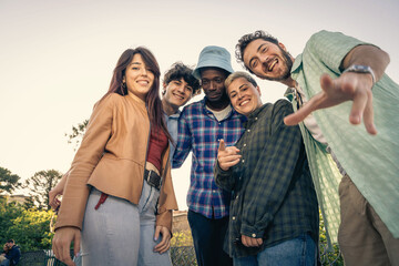Candid shot of a diverse group of friends smiling and laughing together outdoors.