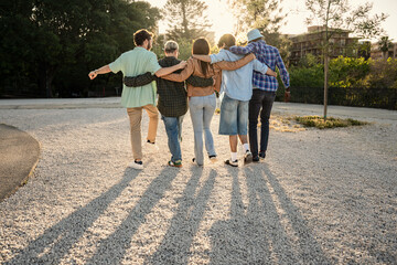 A diverse group of friends walking together on a path into the sunset. Concept of life's journey,...