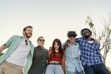 Low angle portrait of a happy multiethnic group of friends looking down at camera. Concept of...