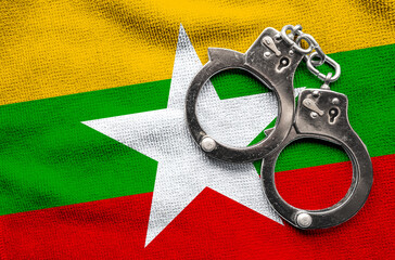 Flag of Myanmar and police handcuffs. Crime and offenses in country Concept
