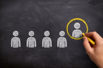 Selection of a person from a group, highlighted with yellow chalk on blackboard