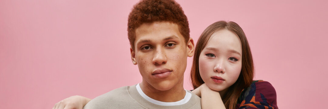 Teenage friends posing in a studio with a pink background